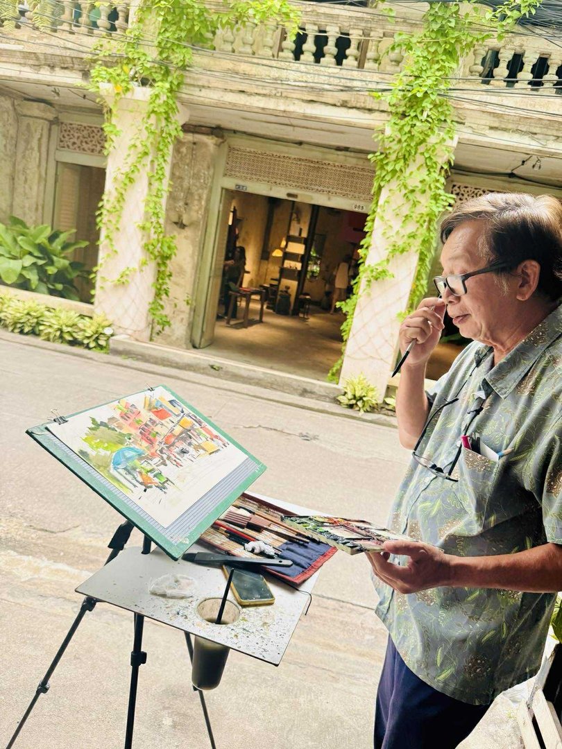 A local street painter surveys the scene outside trendy 965BKK.