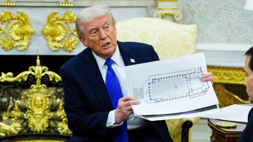 United States President Donald J Trump holds a mockup of the White House ballroom.