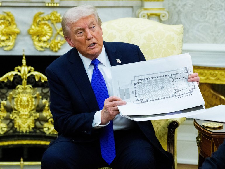 United States President Donald J Trump holds a mockup of the White House ballroom.
