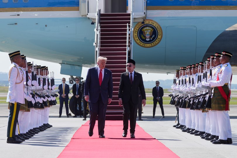 President Donald Trump walks with Malaysia's Prime Minister Anwar Ibrahim as he arrives at Kuala Lumpur International Airport in Sepang, Malaysia, Sunday, Oct. 26, 2025.