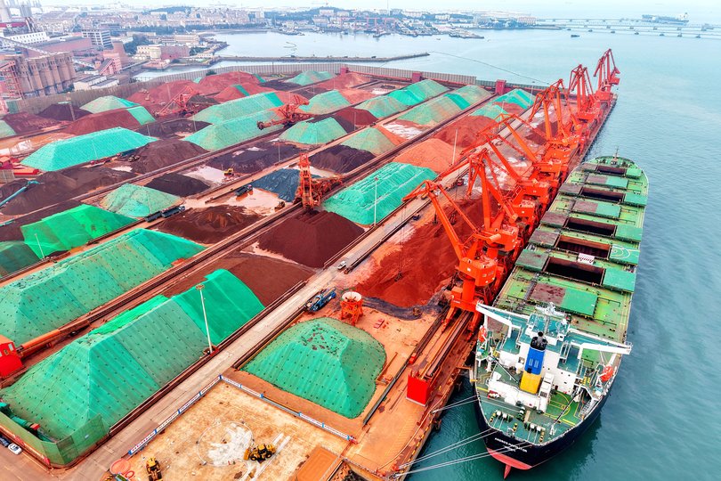 A cargo ship unloads imported iron ore at the Qingdao Port