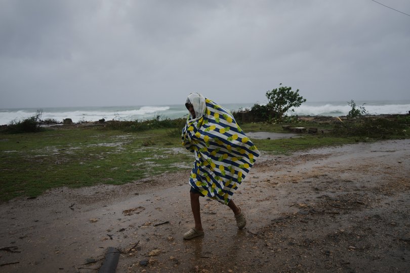 A man walks in the rain before the arrival of Hurricane Melissa in Canizo, a village in Santiago de Cuba, Tuesday.