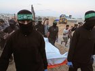 Hamas militants carry a white bag believed to contain a body, during a search for the remains of hostages in Hamad City, Khan Younis, in southern Gaza, on Tuesday, October 28, 2025. 