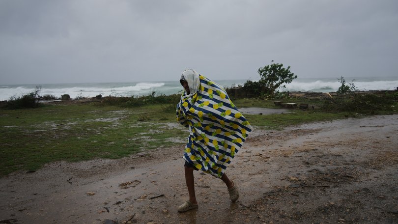 A man walks in the rain before the arrival of Hurricane Melissa in Canizo, a village in Santiago de Cuba, Tuesday, Oct. 28, 2025. (AP Photo/Ramón Espinosa)