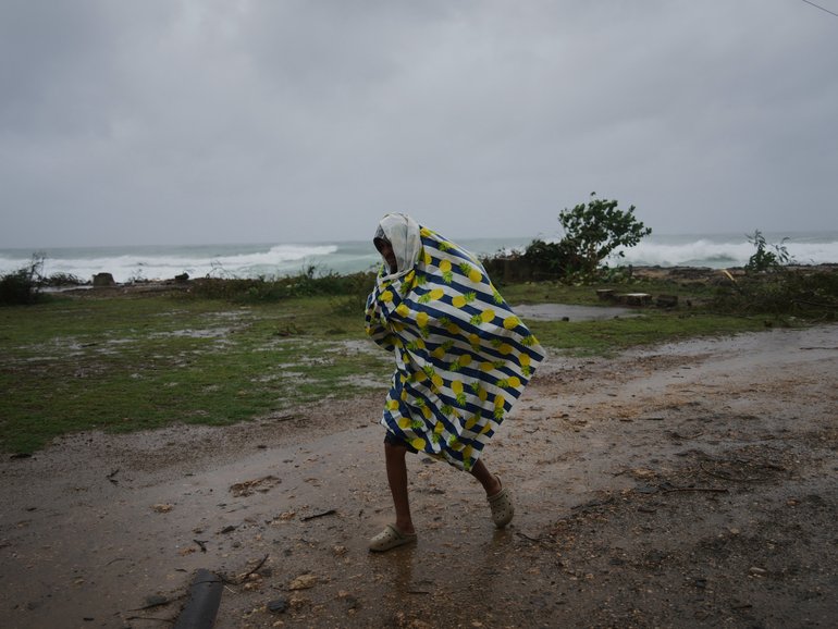 A man walks in the rain before the arrival of Hurricane Melissa in Canizo, a village in Santiago de Cuba, Tuesday, Oct. 28, 2025. (AP Photo/Ramón Espinosa)