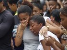 People cry on a street where dead bodies are gathered in Rio de Janeiro, Brazil.