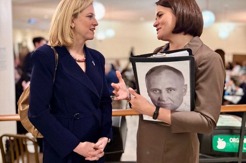 Svitlana Tsikhanouskaya with the folder bearing a picture of her husband, who was imprisoned after announcing his political candidacy.