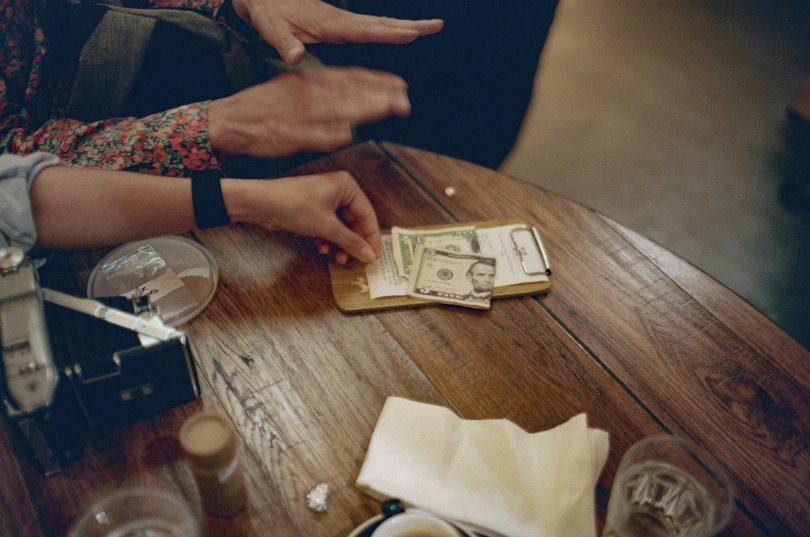 Author Aj Jacobs pays for his lunch with cash after his gold trinkets were rejected, in New York, Sept. 29, 2025.