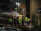 A group of police officers stand close to the emergency equipment left behind after an incident at Huntingdon train station.