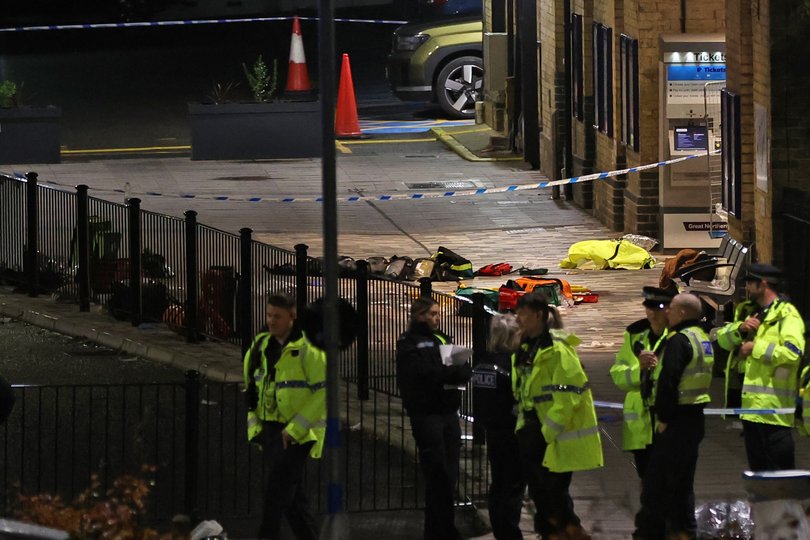 A group of police officers stand close to the emergency equipment left behind after the incident at Huntingdon station in Cambridgeshire.
