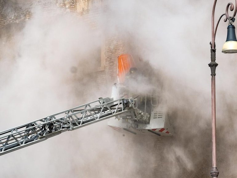 Debris surrounded firefighters trying to rescue a worker from a collapsed tower in Rome. (AP PHOTO)