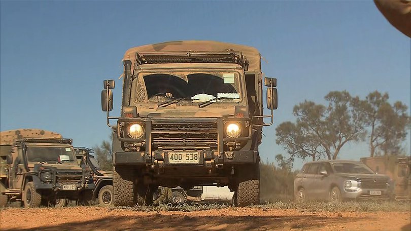 Police and defence force personnel search for the missing four year old.