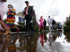 Racegoers walk by rainwater water at Flemington Racecourseto get to the 2025 Melbourne Cup.