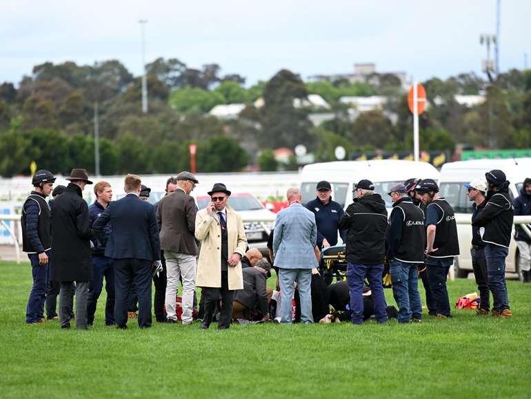 People stand around Blake Shinn after he fell from She's Got Pizzazz at Flemington.