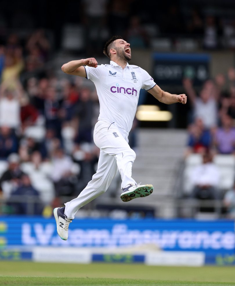 Mark Wood of England celebrates with teammates after dismissing Australia captain Pat Cummins.