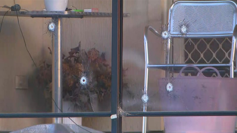 Bullet holes in the glass panels of a balcony.