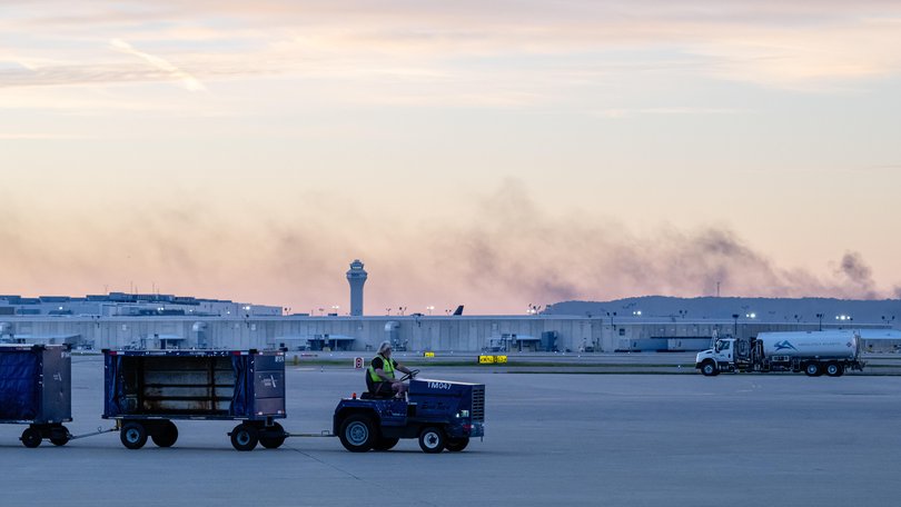 The ATC tower is seen while smoke continues to rise from the crash site of UPS Flight 2976 near Louisville Muhammad Ali International Airport.