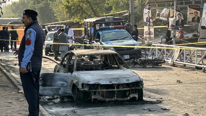 Policemen examine damaged vehicles after a suicide blast outside the district court in Islamabad.