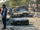 Policemen examine damaged vehicles after a suicide blast outside the district court in Islamabad.