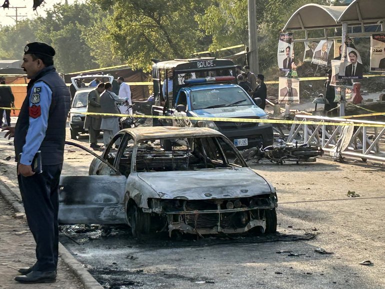 Policemen examine damaged vehicles after a suicide blast outside the district court in Islamabad.