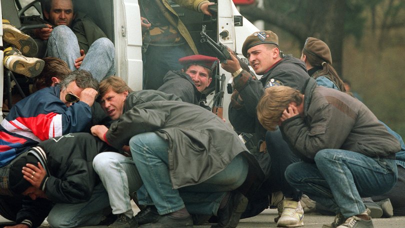 Bosnian soldiers take aim at snipers as civilians take cover in the streets of Sarajevo in the 1990s.  