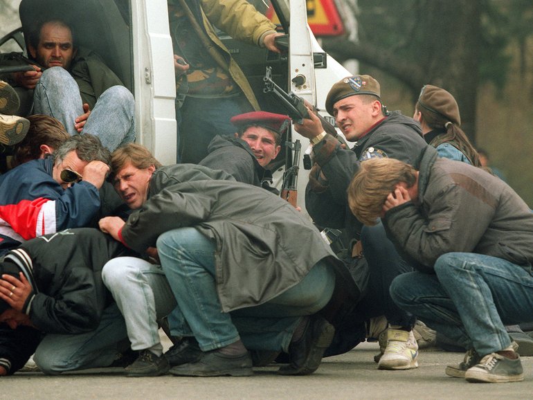 Bosnian soldiers take aim at snipers as civilians take cover in the streets of Sarajevo in the 1990s.  