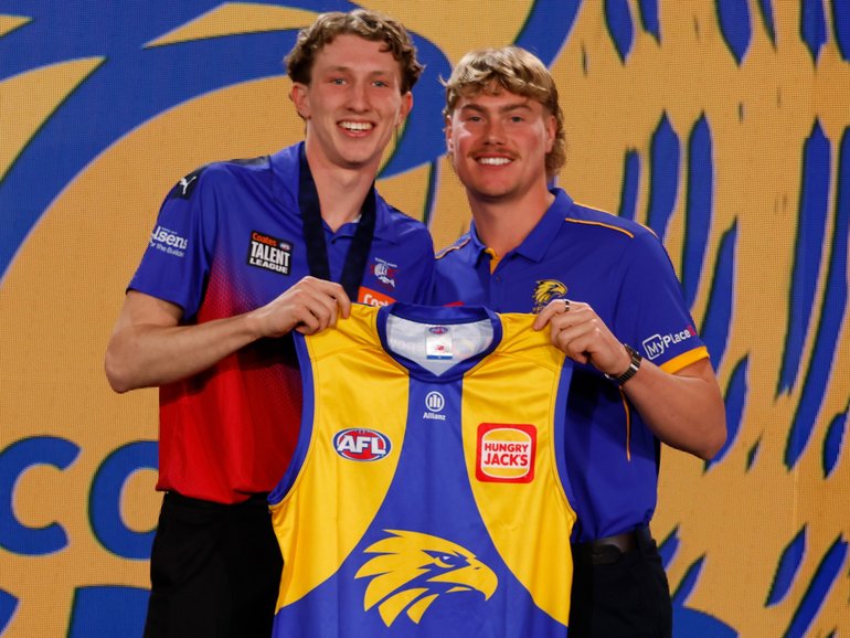 Willem Duursma is presented with his Eagles jumper by Harley Reid.