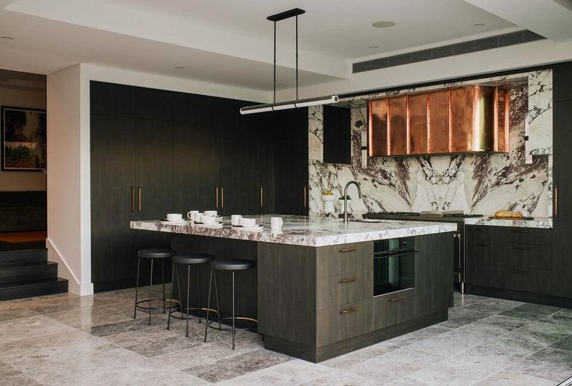 The kitchen has Calacatta Viola stone, a copper range hood and premium appliances.