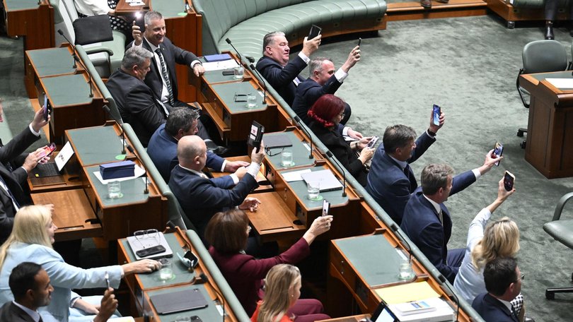 Opposition MPs held up their smartphone torches during the blackout in Federal Parliament.