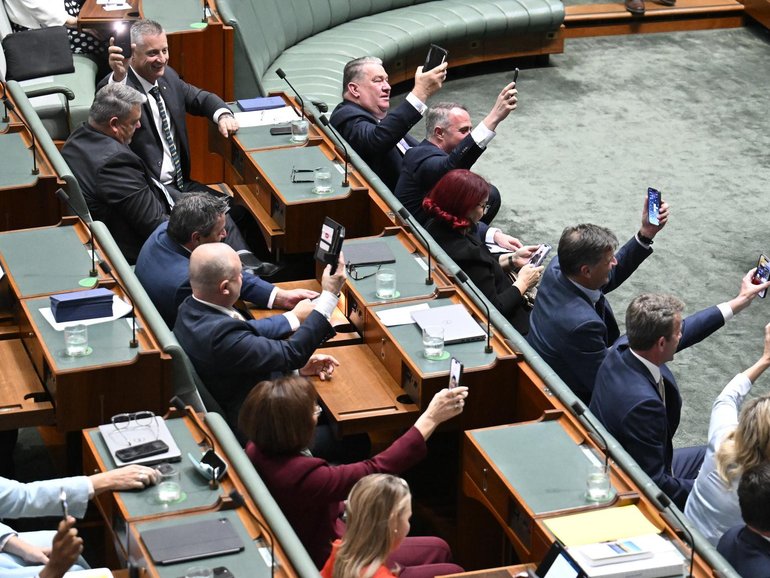 Opposition MPs held up their smartphone torches during the blackout in Federal Parliament.