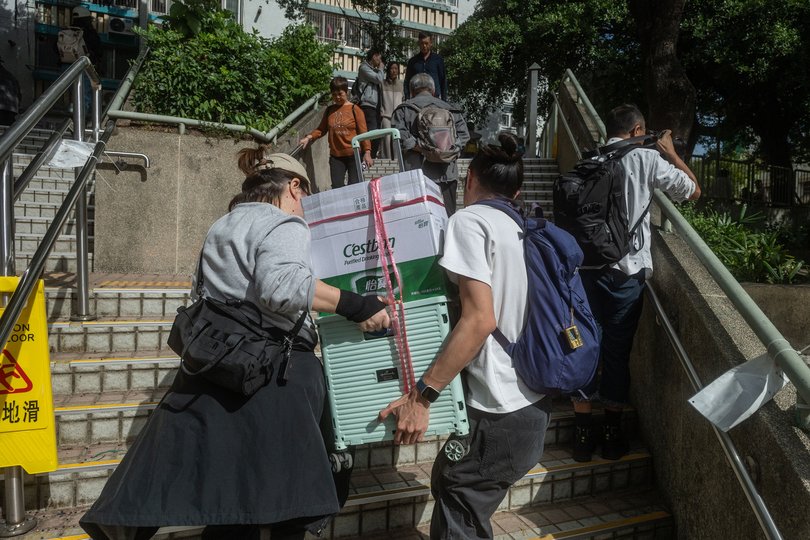 Francis Yu, left, transports food and water at a residential complex fire in Tai Po, Hong Kong on Nov. 27, 2025. Authorities said flammable netting and foam boards may have fueled the city’s deadliest blaze in nearly 70 years. (Lam Yik Fei/The New York Times)