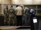 National Guard members participate in a group prayer with civilians and a security officer outside the emergency entrance to MedStar Washington Hospital Center on Wednesday after two Guard members were shot earlier in the day. 