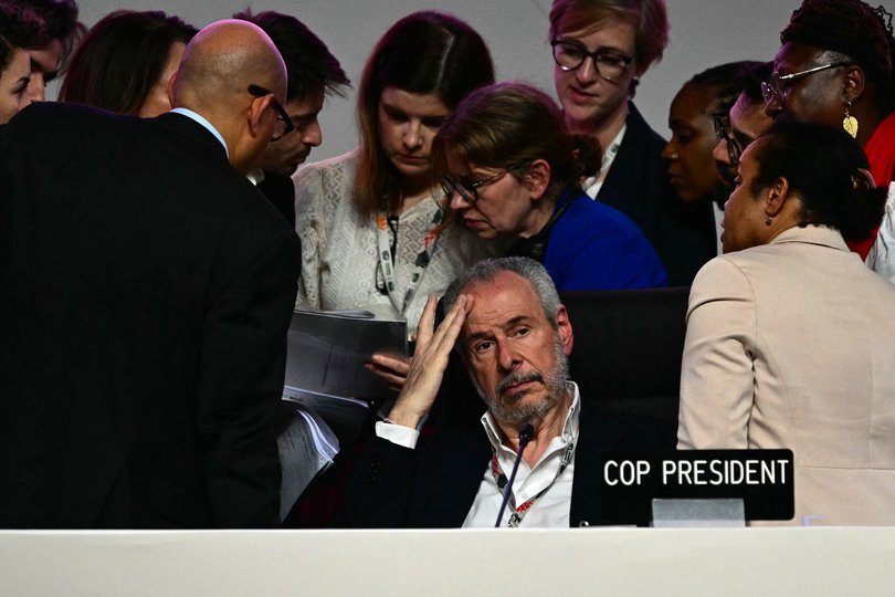 COP30 President Andre Correa do Lago (C) gestures next to his advisers after the plenary session was interrupted following Colombia's intervention at the COP30 UN Climate Change Conference in Belem, Para state, Brazil, on November 22, 2025. A proposed final deal for the UN climate talks omits any direct mention of phasing out fossil fuels, as demanded by the EU and many countries, according to the text published Saturday after two weeks of fraught negotiations. The draft, which must be approved by consensus by nearly 200 nations, calls on developed countries to "at least triple" financing to help poorer nations adapt to the impacts of climate change. (Photo by Pablo PORCIUNCULA / AFP)
