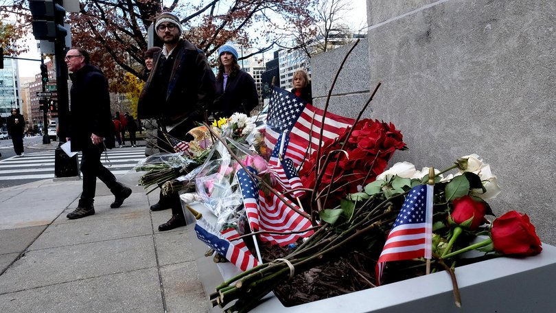 People walk by a memorial at the Farragut West Metro station in Washington on Friday, near the site of the shooting that killed National Guard Spec. Sarah Beckstrom and critically wounded Air Force Staff Sgt. Andrew Wolfe.