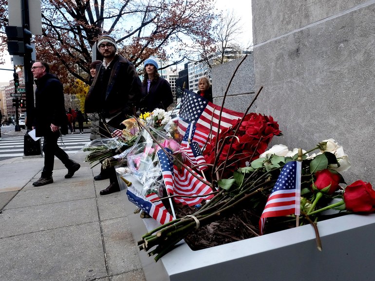 People walk by a memorial at the Farragut West Metro station in Washington on Friday, near the site of the shooting that killed National Guard Spec. Sarah Beckstrom and critically wounded Air Force Staff Sgt. Andrew Wolfe. 