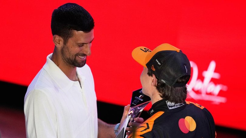 Oscar Piastri receiving his trophy for winning the Qatar GP sprint from Novak Djokovic.