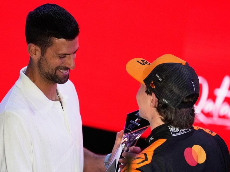 Oscar Piastri receiving his trophy for winning the Qatar GP sprint from Novak Djokovic.