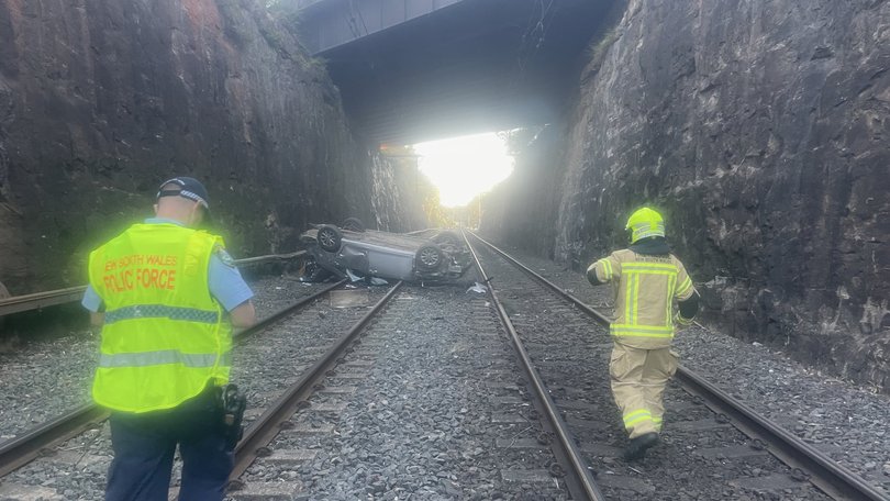 A car has plunged off a bridge and landed on railway tracks in the Blue Mountains.