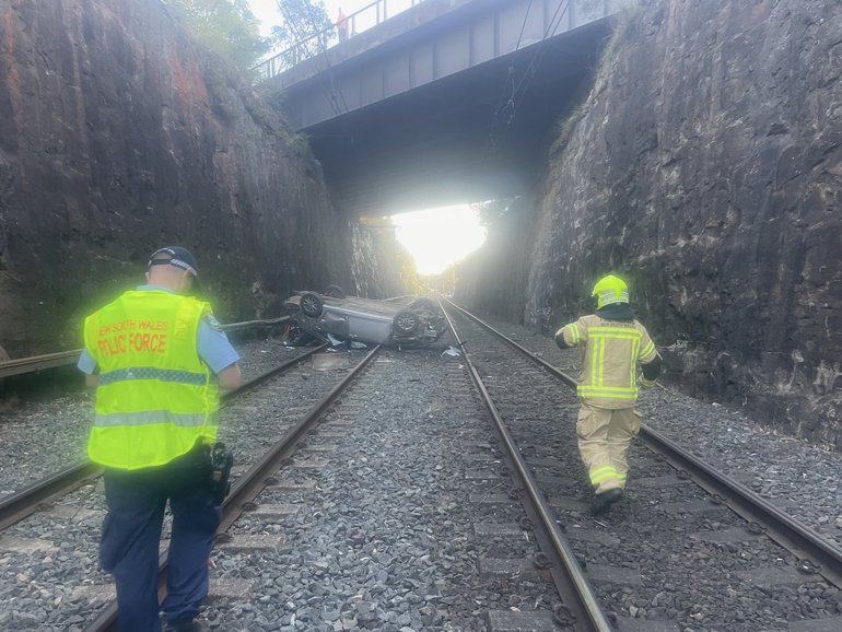 A car has plunged off a bridge and landed on railway tracks in the Blue Mountains.