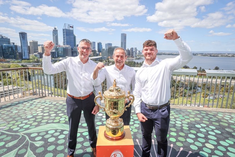 Managing director of Rugby World Cup 2027 Chris Stanley, Premier Roger Cook, and Wallabies player Carlo Tizzano pose for a photo with the Webb Ellis Cup at Kings Park, Perth, on Wednesday ahead of the 2027 Rugby World Cup.