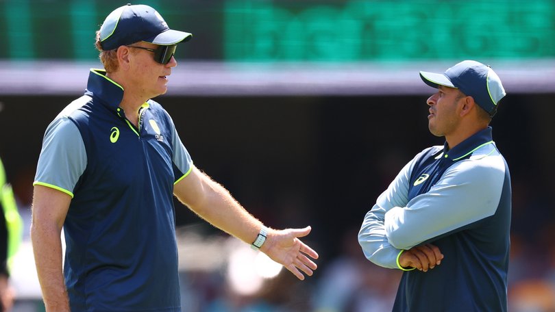 Australian coach Andrew McDonald speaks with Usman Khawaja at the Gabba on Sunday.