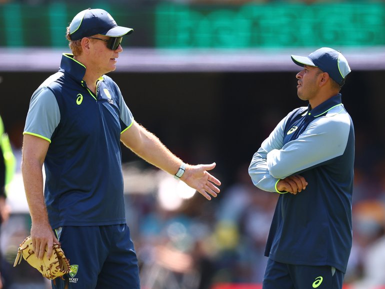 Australian coach Andrew McDonald speaks with Usman Khawaja at the Gabba on Sunday.