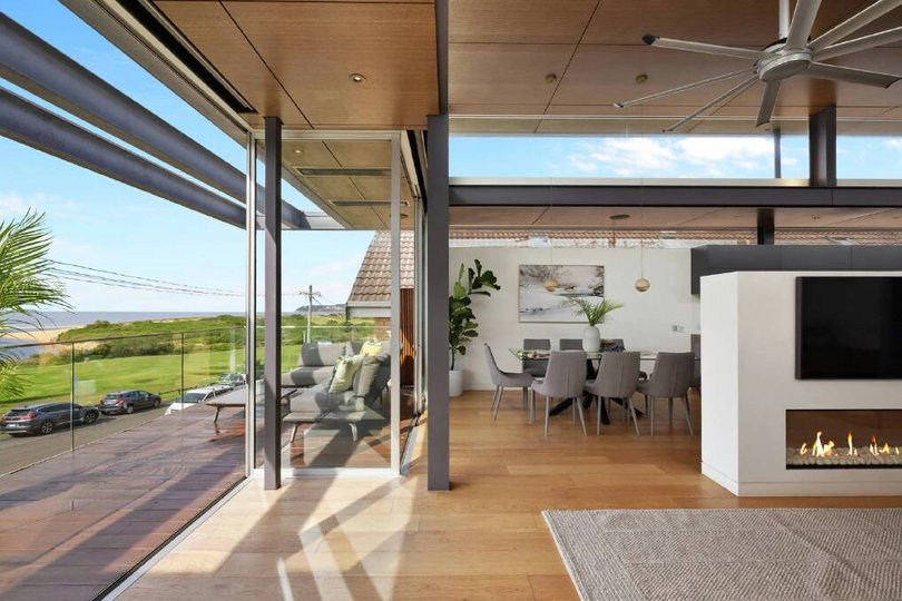 A double-sided fireplaces separates the dining and living.