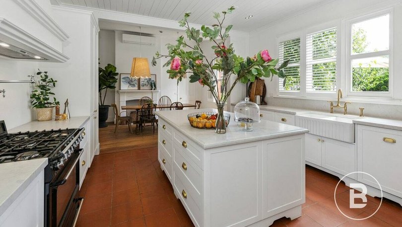 The modern kitchen features shaker-style cabinetry and high-end appliances.