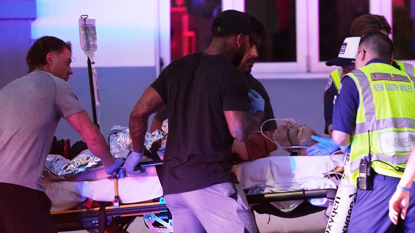 Emergency workers transport a person on a stretcher after the shooting at Bondi beach.