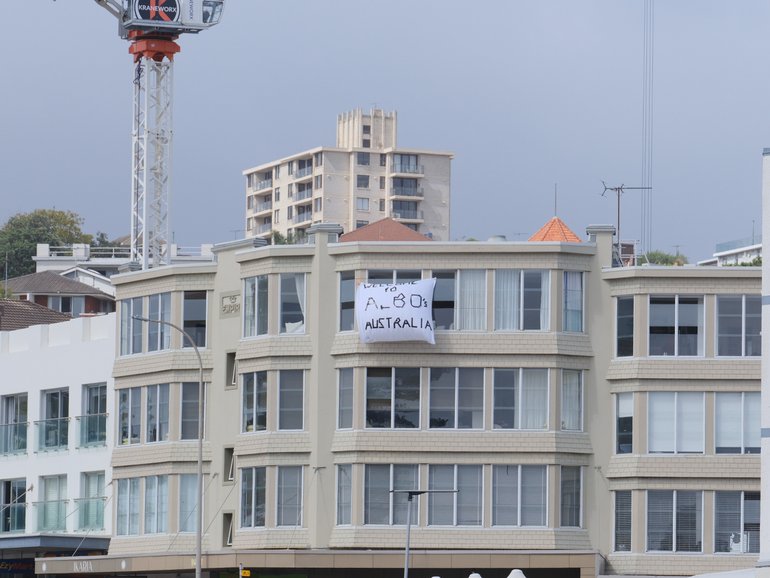 SYDNEY, AUSTRALIA - DECEMBER 15: A banner is seen on a building stating 'Welcome to Albo's Australia" referring to Prime Minister Anthony Albanese at Bondi Beach on December 15, 2025 in Sydney, Australia. Police say at least 10 people, including one suspected gunman, were killed and more than a dozen others injured when two attackers opened fire near a Hanukkah celebration at the world-famous Bondi Beach, in what authorities have declared a terrorist incident. (Photo by George Chan/Getty Images)