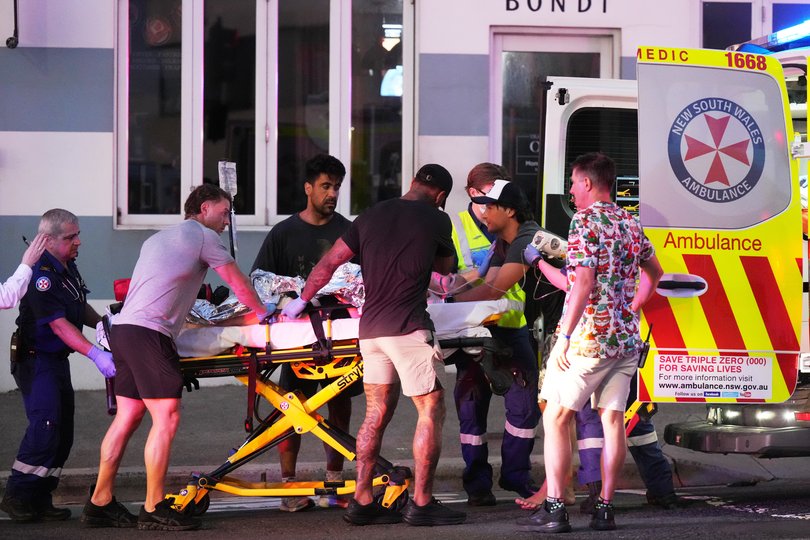 Emergency workers transport a person on a stretcher after a reported shooting at Bondi Beach in Sydney, Sunday, Dec. 14, 2025. (AP Photo/Mark Baker)