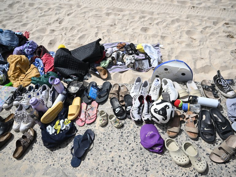 Personal items collected from the beach are placed on the access ramps after lifeguards collected the discarded items from the beach at the site where two gunmen opened fire at Bondi Beach.