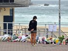 Mourners continue to gather at Bondi as the premier defends police who confronted the perpetrators. (Mick Tsikas/AAP PHOTOS)