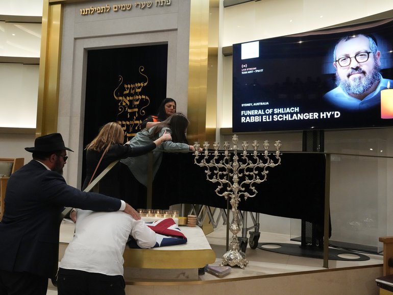Family react at the coffin of Rabbi Eli Schlanger, a victim in the Bondi Beach mass shooting, during his funeral at a synagogue in Bondi.